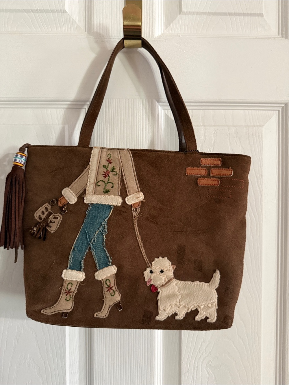 Valerie Steven’s hand stitched purse brown suede Girl walking white dog